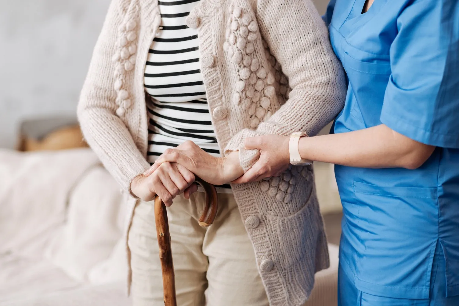 Sanfte ausgebildete Krankenschwester hilft älterem Patienten